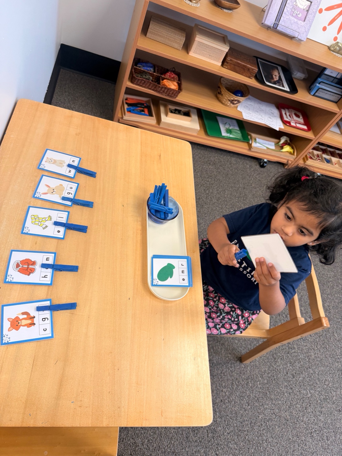 child matching letters with clothespin cards